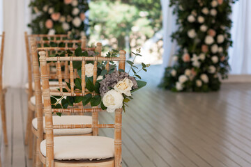 The wooden chair is decorated with flowers in honor of the wedding.