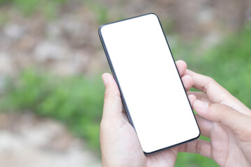 Man's hands holding or using smartphone with two hands. Smartphone with white blank on screen, Cellphone mockup.