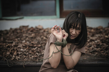 Asian hostage woman Bound with rope at night scene,The thieves kidnapped for ransom,thailand people