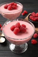 Delicious raspberry mousse on black wooden table