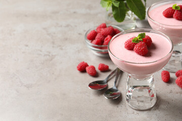 Delicious raspberry mousse with mint on light grey table, space for text