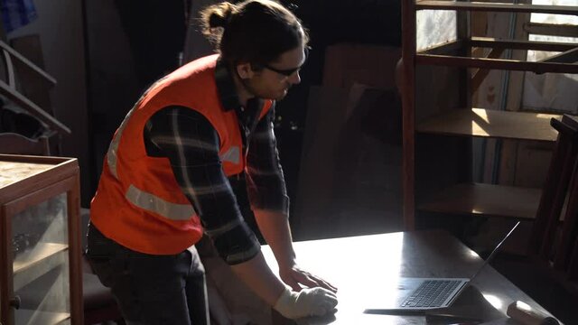 Unhappy carpenter man Disappointed  with computer laptop .tired  Business Owner wood worker In Workshop 