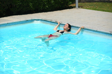 Naklejka premium Portrait of a woman doing aquafitness in the outdoor swimming pool