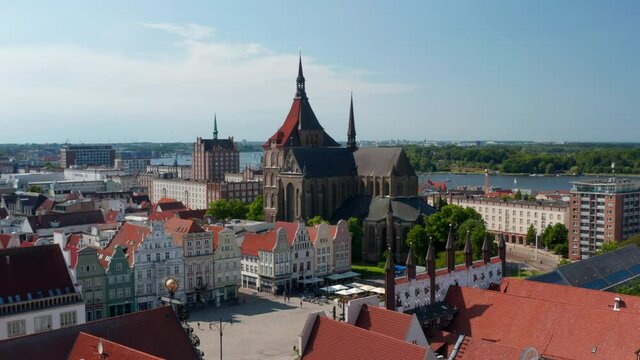 Fly over historic city centre, square with old typical colourful gabled houses. Orbiting around Saint Marys church. Large brick gothic