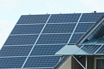 Fototapeta premium gray solar panels on the roof of a private house against the sky