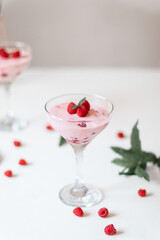 Delicious dessert, cheesecake with fresh raspberries and butter cream mousse in glass on a white table. Copy space