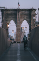 people walking on the bridge bike Brooklyn bridge New York morning sunrise cold 