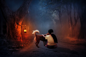 A little girl sits alone with a dog under the lamplight.