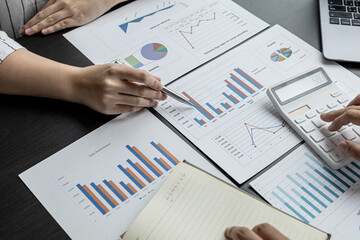 Two businessmen are reviewing the earnings summary and company financial documents that each department produces and submits for monthly audits. Concept of checking company information sheet.