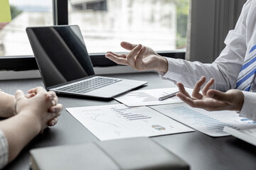 A businessman is explaining to his business partners in detail how to solve a sales fall problem so that they can make joint decisions to manage their sales growth. Company management concept.