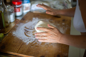 person kneading dough on the table