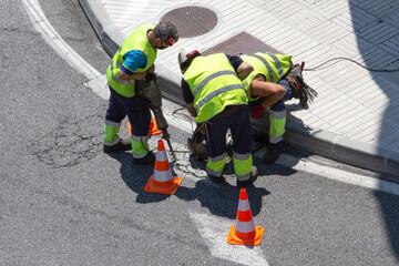 Group of construction Workers repairing an asphalt road on city. Paving maintenance
