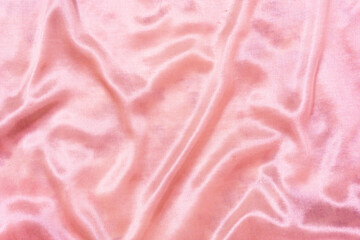Luxury pink or pink gold silk background. Rippled silk fabric, drapery cloth, or satin texture	