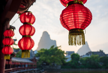 Look at the mountains from a room where hangs many red lanterns. The place is in Hezhou, Guangxi, China.