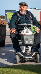 Оld man rides a special scooter with four wheels for the disabled people. Electric car transport...