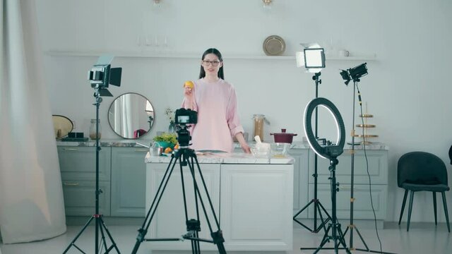 Young woman is filming a cooking vlog in a professional studio