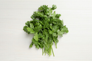Bunch of fresh green cilantro on white wooden table, top view