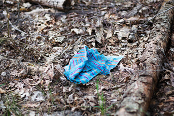 Ręcznik porzucony w lesie, przykład zaśmiecania lasu - obrazy, fototapety, plakaty