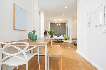 Studio apartment with minimalist decor with dining table in the foreground and bedroom in the background in a vacation rental apartment