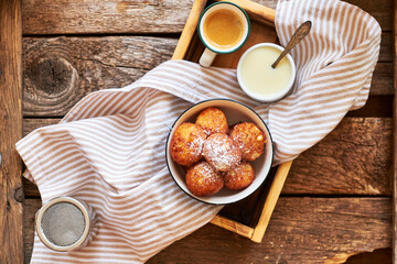 Round curd donuts. Sweet white sauce, fried balls. Top view. Coffee, rustic.