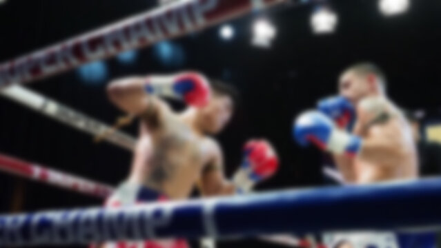 Thai Kick boxing. Blurred images of Muay Thai. Martial Art Kickboxing. Local and foriegn boxer are fighting on the ring at indoor stadium stage. Muaythai is sport competition for traveller sightseeing