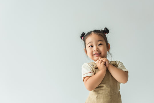 Cheerful Asian Toddler Girl Smiling Isolated On Grey