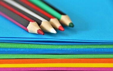 colored pencils and multicolored thick paper close-up 