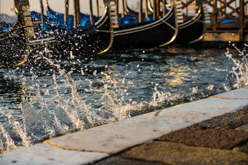 Fototapeta na wymiar Splashing waves at dawn on the embankment of San Marco, Venice, Italy