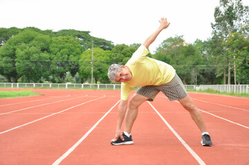 Obraz premium an old man warming up exercise before running or jogging, concept health care in elderly people