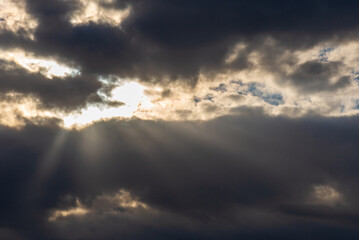 Fototapeta na wymiar Rays of light shining throug dark clouds.Beautiful dramatic sky with sun rays.