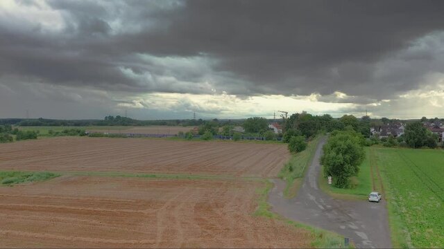 Drone video of Dornheim settlement in southern Hesse with passing high-speed train during approaching thunderstorm