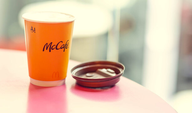 Mcdonalds, Poland Restaurant - Nowy Sacz - July 3, 2021. Cup of coffee at Mcdonalds. McCafe coffee on a pink table.