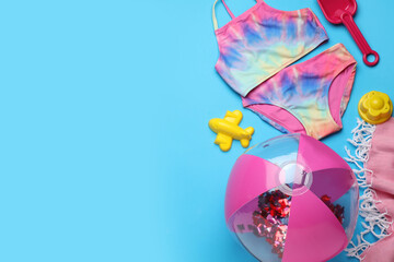 Flat lay composition with beach ball and sand toys on light blue background, space for text