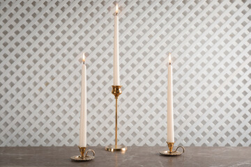 Elegant candlesticks with burning candles on marble table