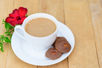 Top view of hot coffee with cookie on wood plate