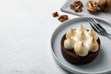 Fototapeta na wymiar Delicious salted caramel chocolate tart with meringue served on light table, space for text