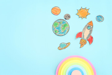 Painted rocket and planets over wooden blue background