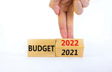Planning 2022 budget new year symbol. Businessman turns a wooden cube and changes words 'Budget 2021' to 'Budget 2022'. Beautiful white background, copy space. Business, 2022 budget new year concept.