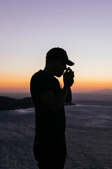 Un hombre excursionista mirando el atardecer junto a la frontera de Benzú