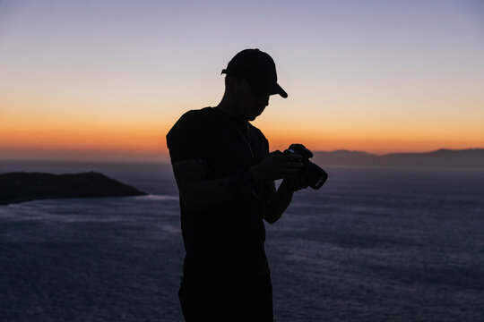 Un hombre excursionista mirando el atardecer junto a la frontera de Benz&uacute;