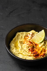 Cheakpea Hummus bowl with red smoked paprika and lime. Healthy snack concept.