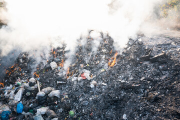 Garbage and fire burn in landfill. Also call trash, waste, rubbish. Destruction with combustion,...