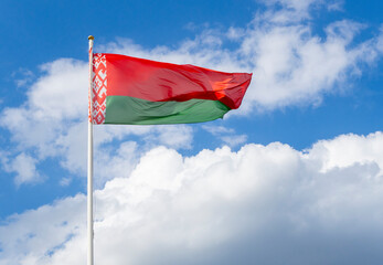 Flag of Belarus on flagpole waving against blue sky