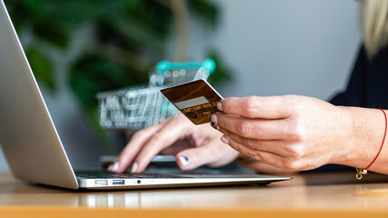 e-commerce concept, woman with credit card and laptop, close-up