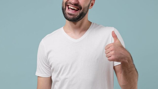 Close up cropped smiling happy unshaven man wearing white print design blank t-shirt pointing index fingers on himself place for promo advert copy space isolated on plain pastel light blue background