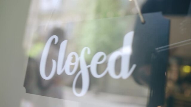 Closed sign hanging on door, small business facing financial crisis, bankruptcy