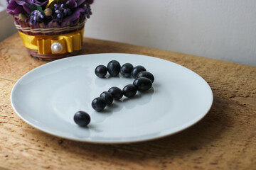 The question mark is set out from grape berries on a white plate