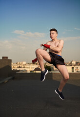 Fototapeta na wymiar Kickbox fighter training in urban environment