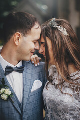 Beautiful emotional wedding couple laughing and hugging in european city. Provence wedding. Stylish happy bride and groom smiling and embracing on background of old church