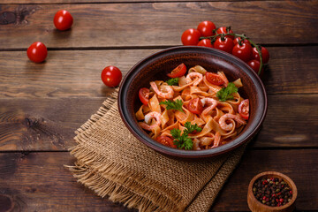 Fettuccine pasta with shrimp, cherry tomatoes, sauce, spices and herbs
